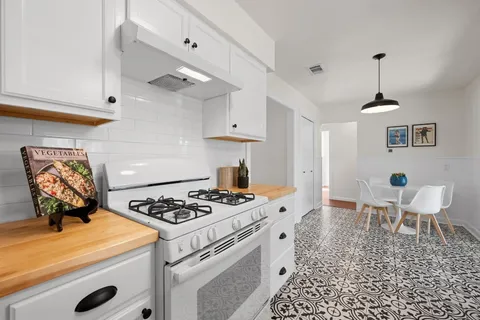 a kitchen with a stove a table and chairs