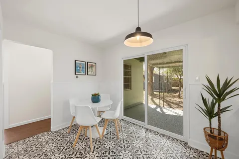 a dining room with furniture and a floor to ceiling window