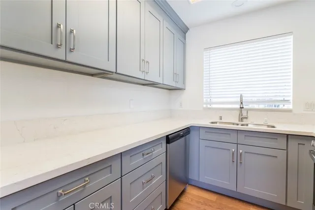 a kitchen with white cabinets and sink
