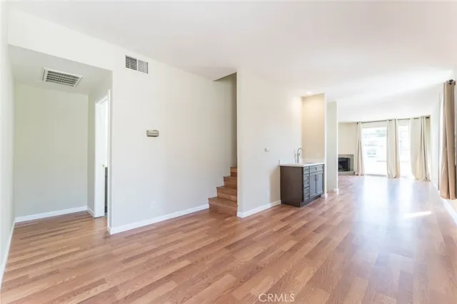 a view of a big room with wooden floor and windows