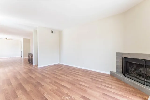 a view of empty room with wooden floor and fireplace