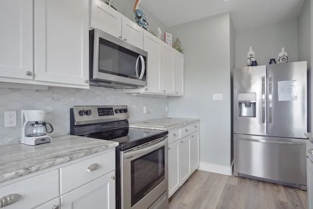 a kitchen with granite countertop a sink and a stove top oven with wooden floor