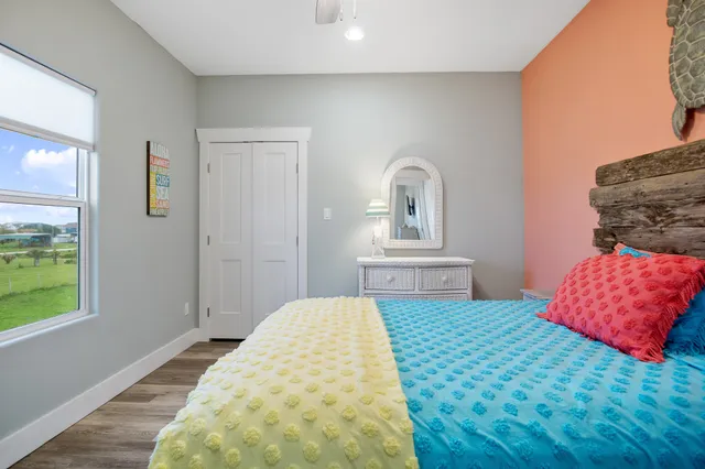 a bedroom with a bed a window and dresser