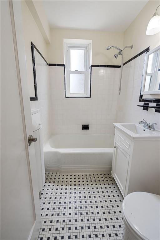 6801 Shore Road, Unit 4J Brooklyn, NY 11220 - Photo 12 of 15 a bathroom with a bathtub a sink toilet and a mirror