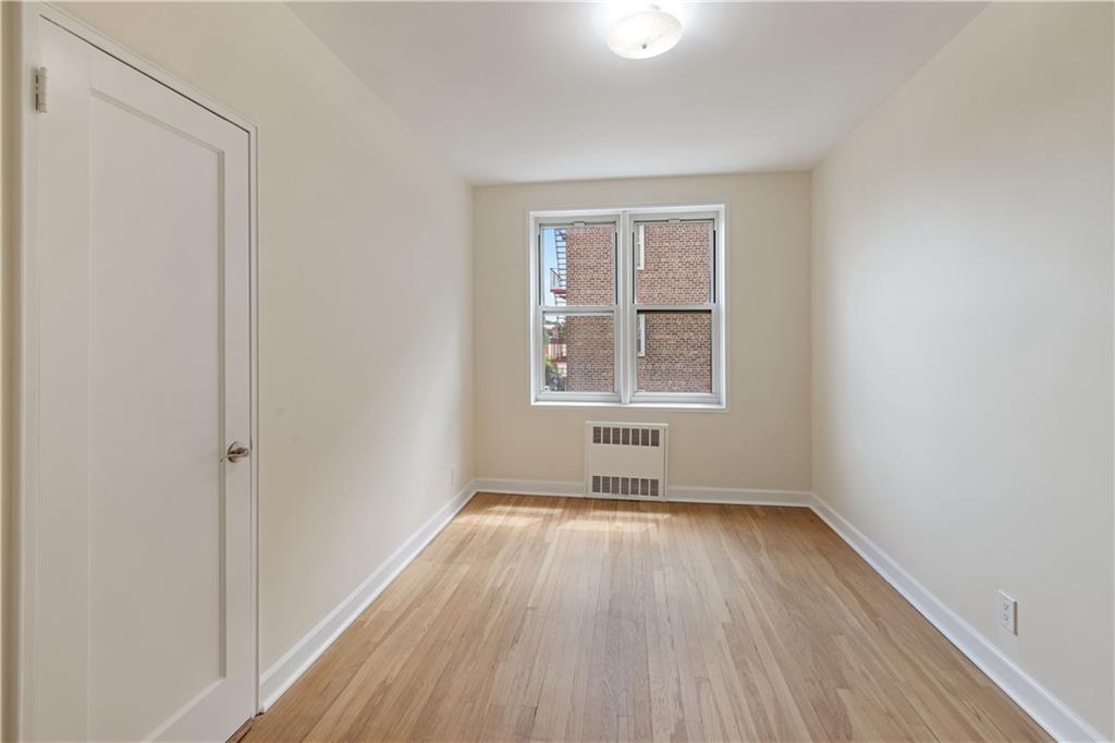 6801 Shore Road, Unit 4J Brooklyn, NY 11220 - Photo 14 of 15 an empty room with wooden floor and windows