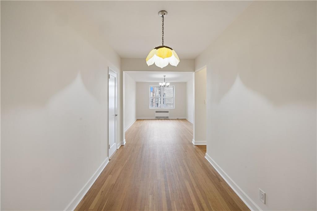 6801 Shore Road, Unit 4J Brooklyn, NY 11220 - Photo 2 of 15 a view of a hallway with wooden floor and chandelier