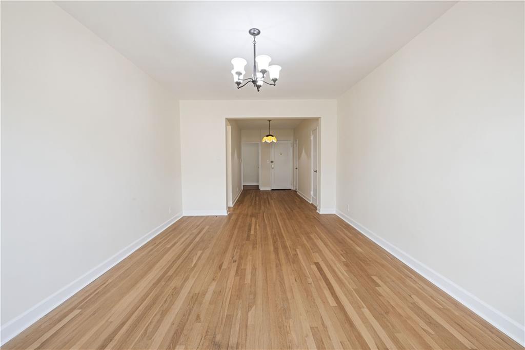 6801 Shore Road, Unit 4J Brooklyn, NY 11220 - Photo 4 of 15 a view of a room with wooden floor staircase and a kitchen