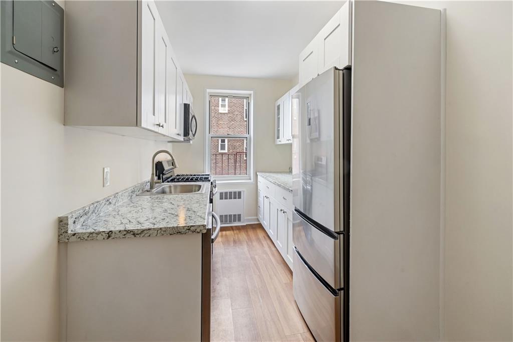 6801 Shore Road, Unit 4J Brooklyn, NY 11220 - Photo 7 of 15 a kitchen with stainless steel appliances granite countertop a refrigerator and a sink