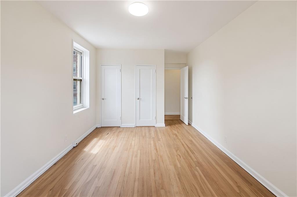 6801 Shore Road, Unit 4J Brooklyn, NY 11220 - Photo 10 of 15 a view of an empty room with wooden floor and a window