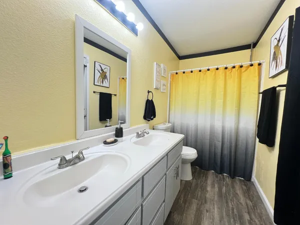 a bathroom with a double vanity sink toilet and shower