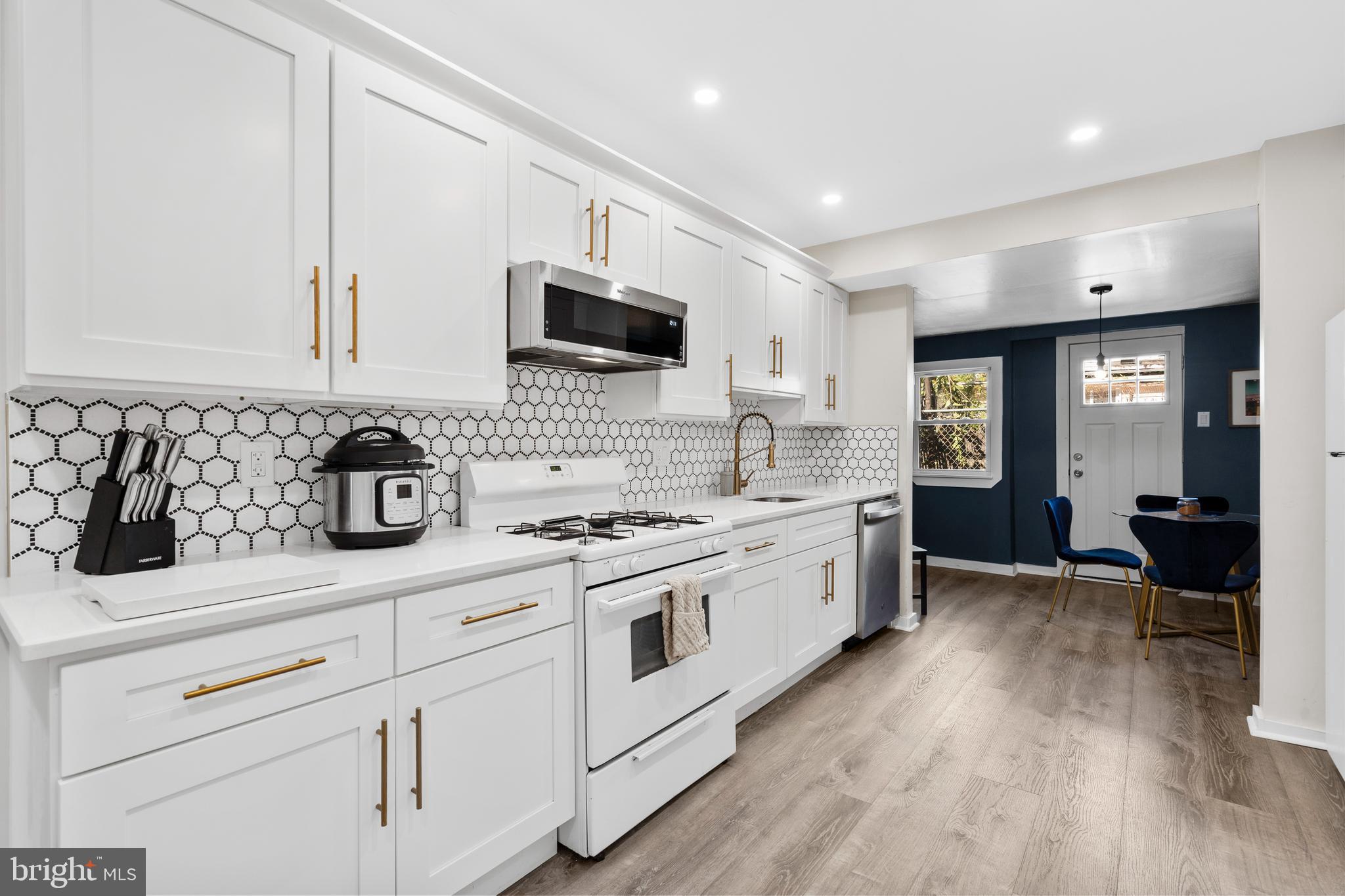 2564 Kern Street Philadelphia, PA 19125 - Photo 9 of 35 a large white kitchen with cabinets and wooden floor
