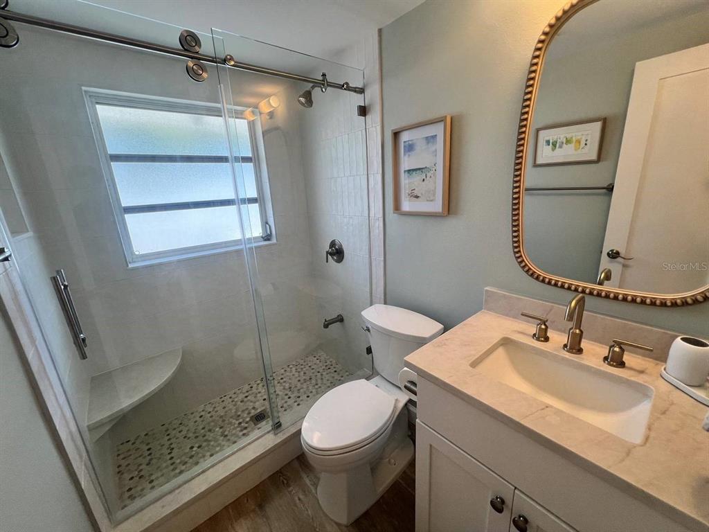 6020 Midnight Pass Road, Unit 45 Sarasota, FL 34242 - Photo 12 of 16 a bathroom with a sink toilet and shower