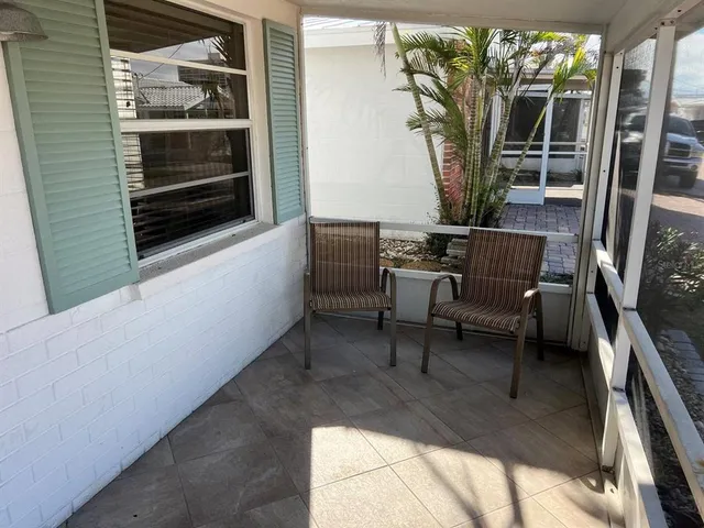 a view of a porch with furniture and a yard