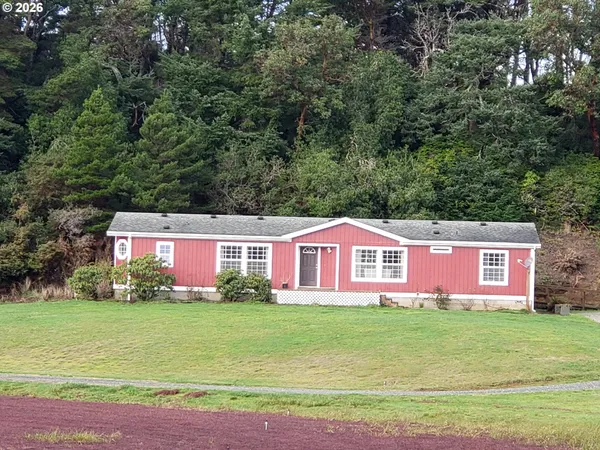 a front view of house with yard and trees in the background