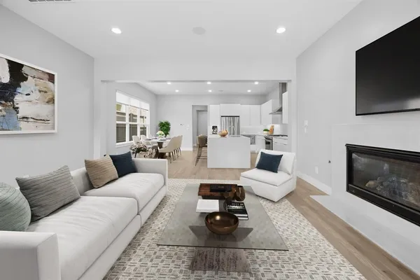 a living room with furniture a flat screen tv and a fireplace
