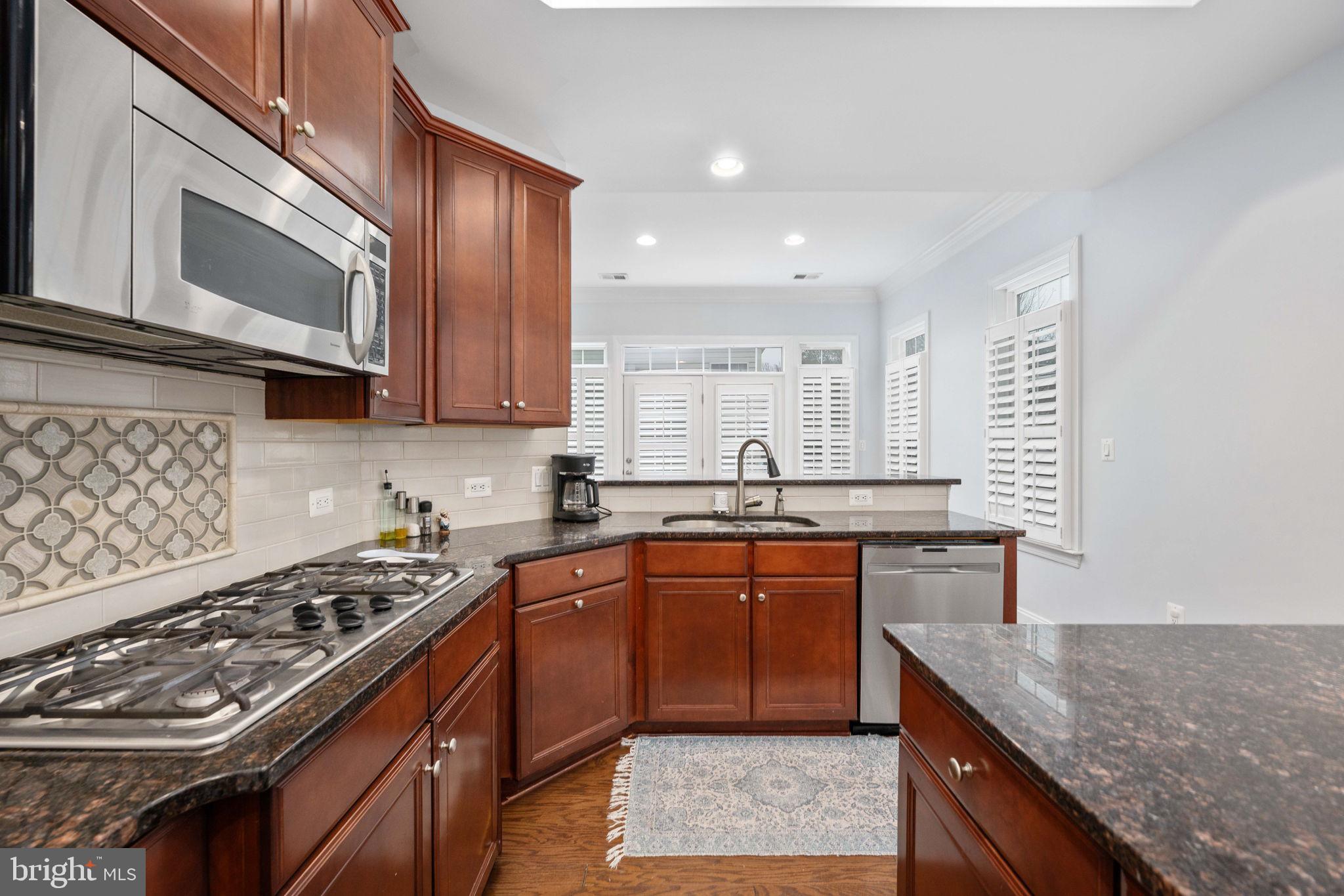 6044 Masondale Road Alexandria, VA 22315 - Photo 21 of 64 a kitchen with stainless steel appliances granite countertop a sink stove and microwave