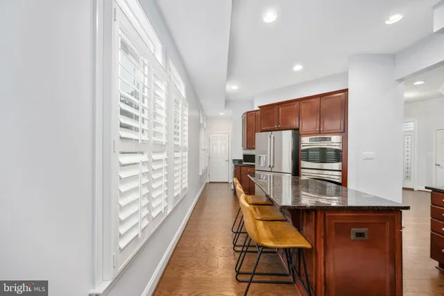 an empty room with chandelier fan and windows