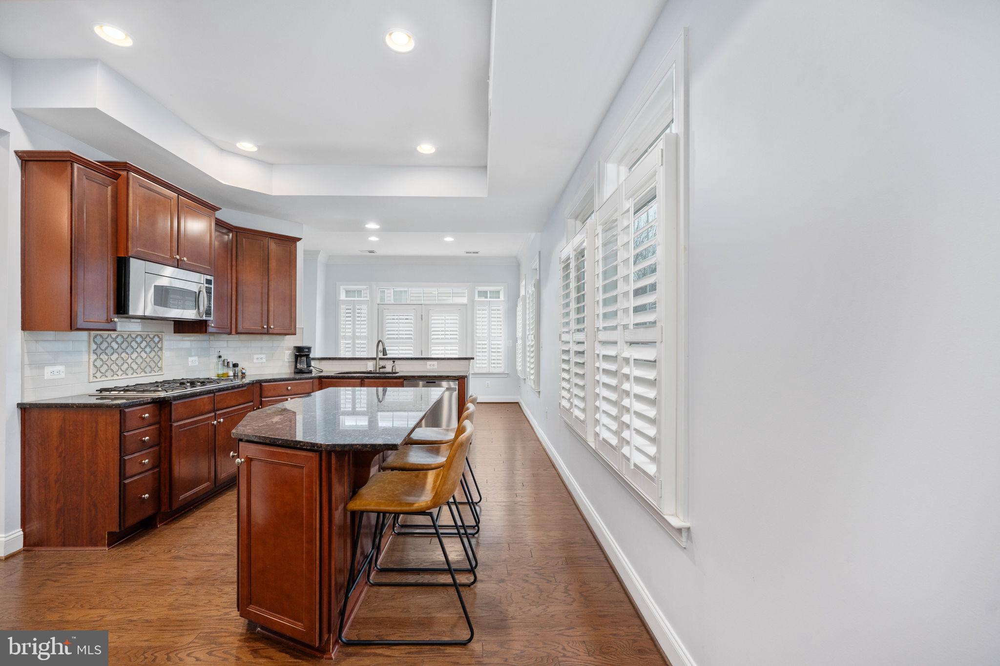 6044 Masondale Road Alexandria, VA 22315 - Photo 25 of 64 a kitchen with stainless steel appliances granite countertop a refrigerator a sink dishwasher a stove with wooden cabinets