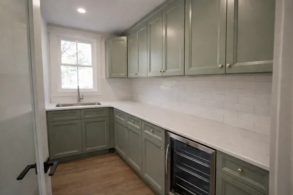 a view of a kitchen with white cabinets