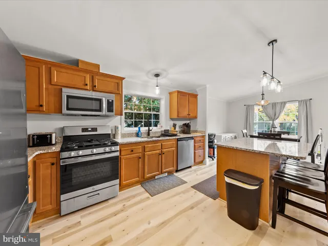 a large kitchen with stainless steel appliances granite countertop a stove and a sink