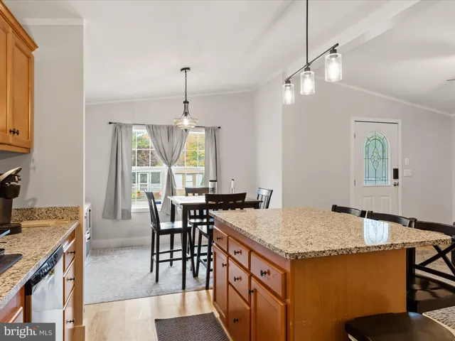 a kitchen with a stove a kitchen island a dining table and chairs