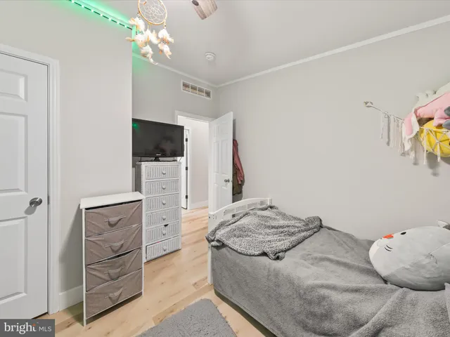 a bedroom with a bed and a flat tv screen on dresser