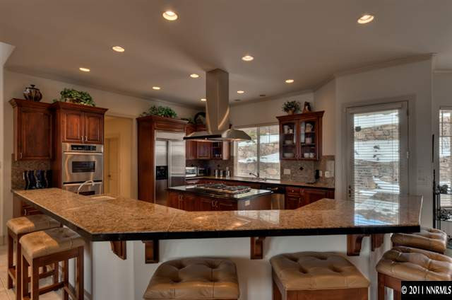 920 Schellbourne Road Reno, NV 89511 - Photo 4 of 13 a kitchen with stainless steel appliances granite countertop a table chairs and a refrigerator
