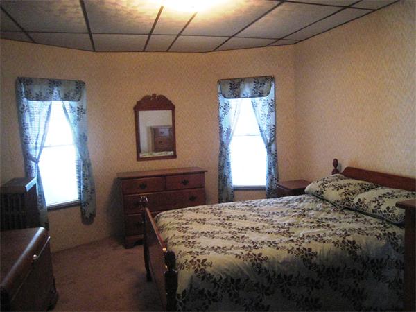 74 Madison Avenue Everett, MA 02149 - Photo 20 of 28 a bedroom with a bed and a dresser next to a window