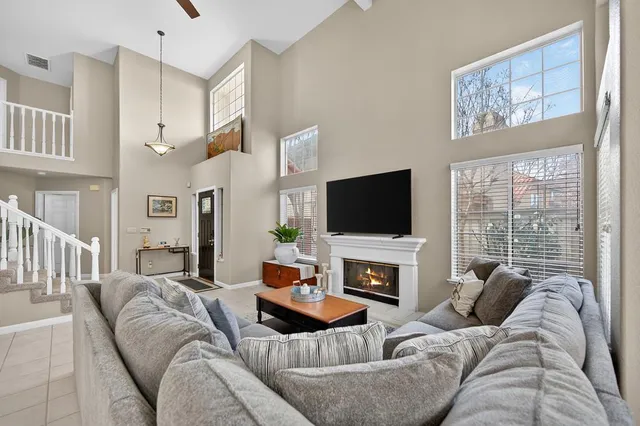a living room with furniture a fireplace and a flat screen tv