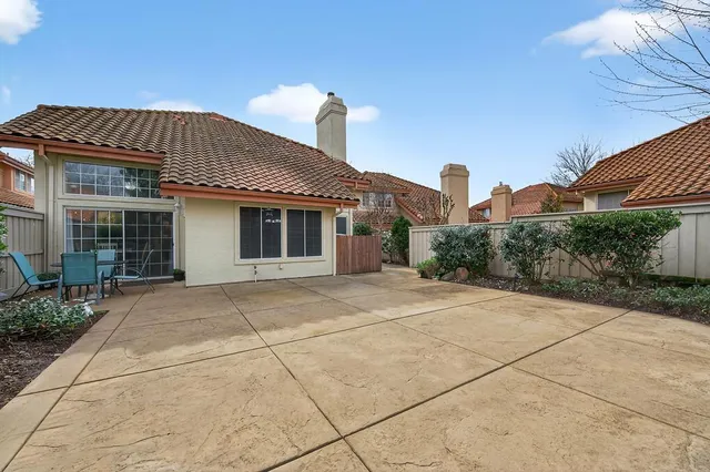 a view of a house with a small yard and potted plants