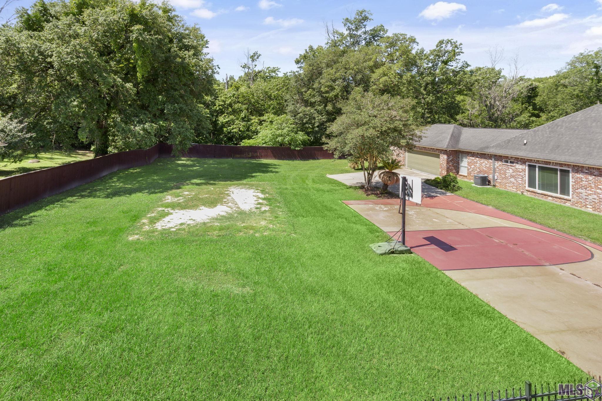 9916 Blakemore Avenue Baton Rouge, LA 70810 - Photo 3 of 16 Additional Side Lot that is totally fenced and has basketball markings