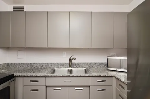 a kitchen with granite countertop white cabinets and sink