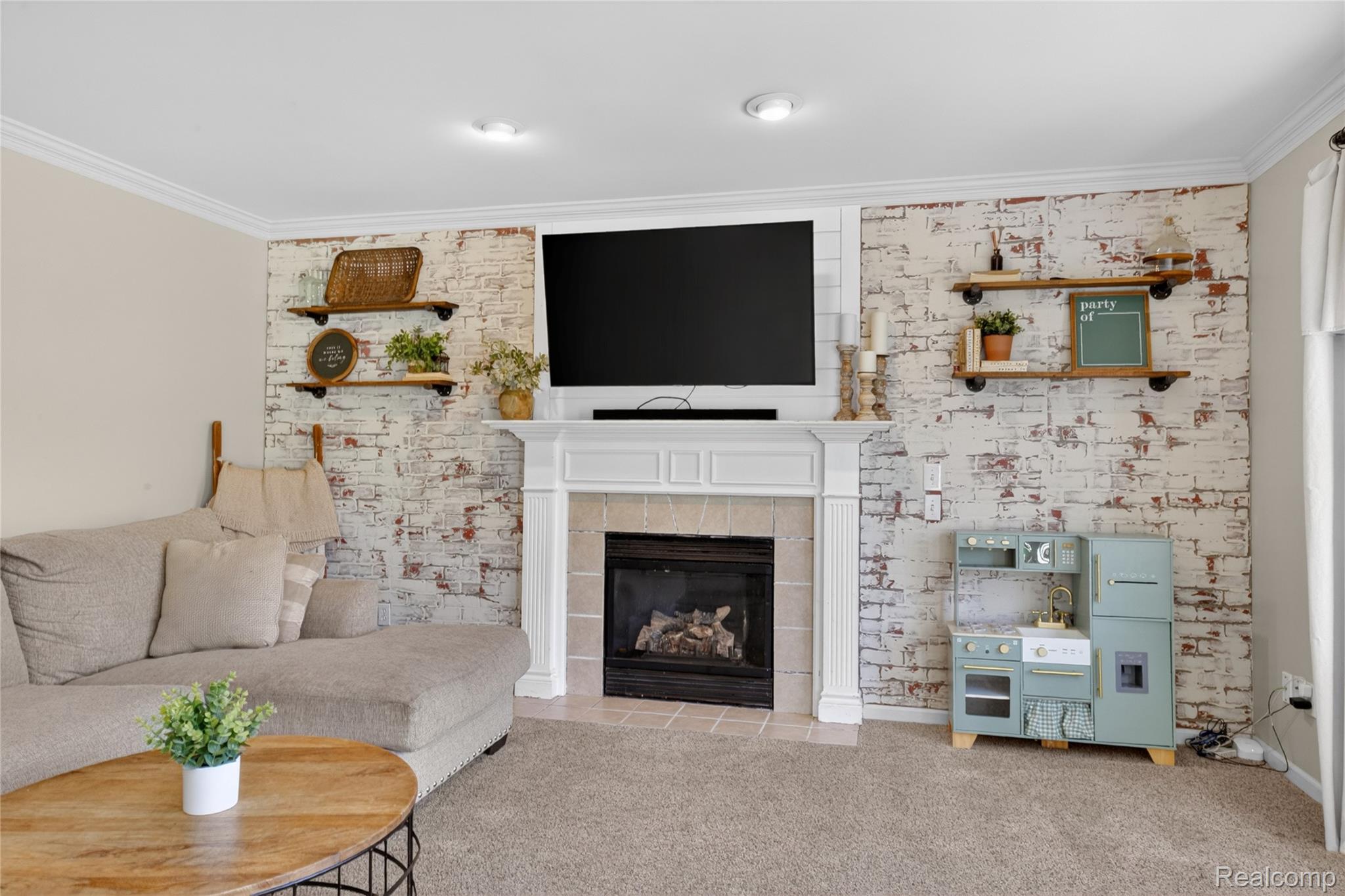 9191 Judd Road Fowlerville, MI 48836 - Photo 20 of 74 Living area featuring a textured accent wall with a white-washed brick finish