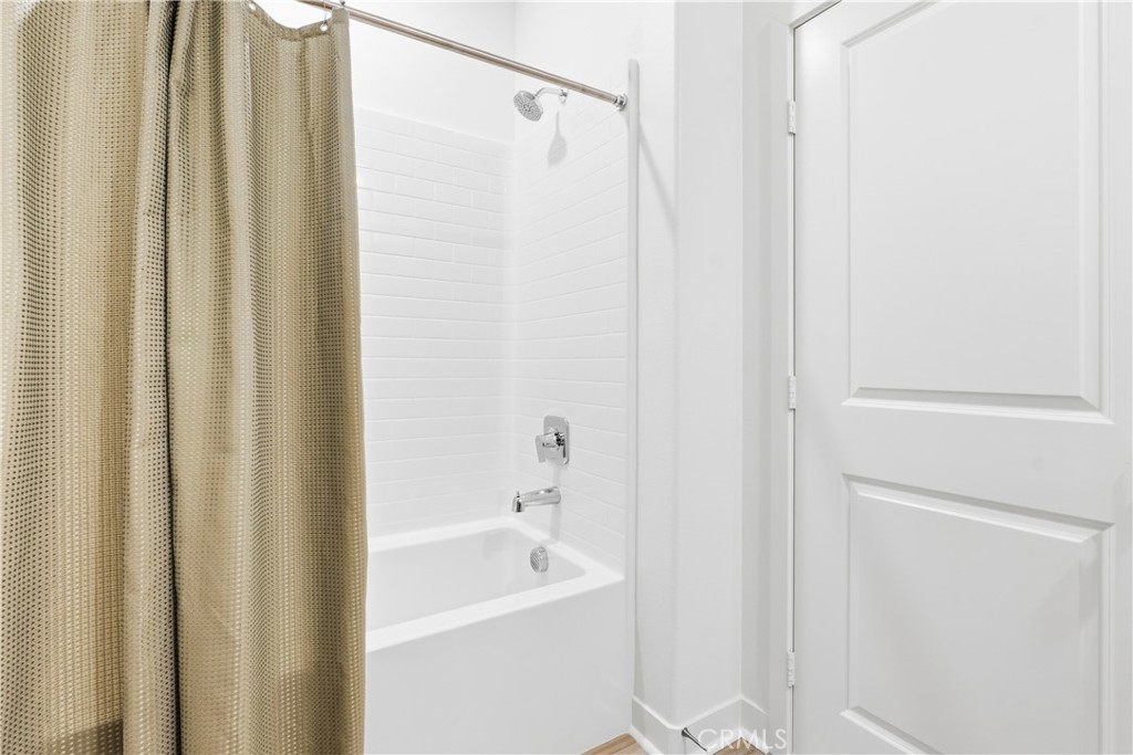 1300 Lasso Way, Unit 305 Rancho Mission Viejo, CA 92694 - Photo 25 of 75 a bathroom with a shower a bath tub and a shower curtain