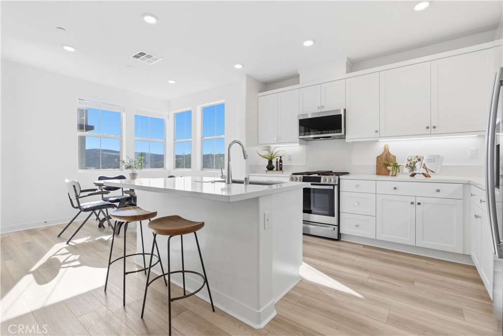 1300 Lasso Way, Unit 305 Rancho Mission Viejo, CA 92694 - Photo 3 of 75 a kitchen with stainless steel appliances kitchen island granite countertop a sink and cabinets
