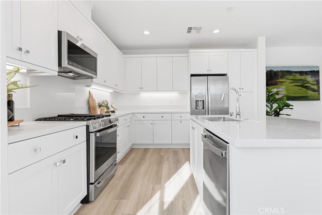 1300 Lasso Way, Unit 305 Rancho Mission Viejo, CA 92694 - Photo 5 of 75 a kitchen with white cabinets stainless steel appliances and sink