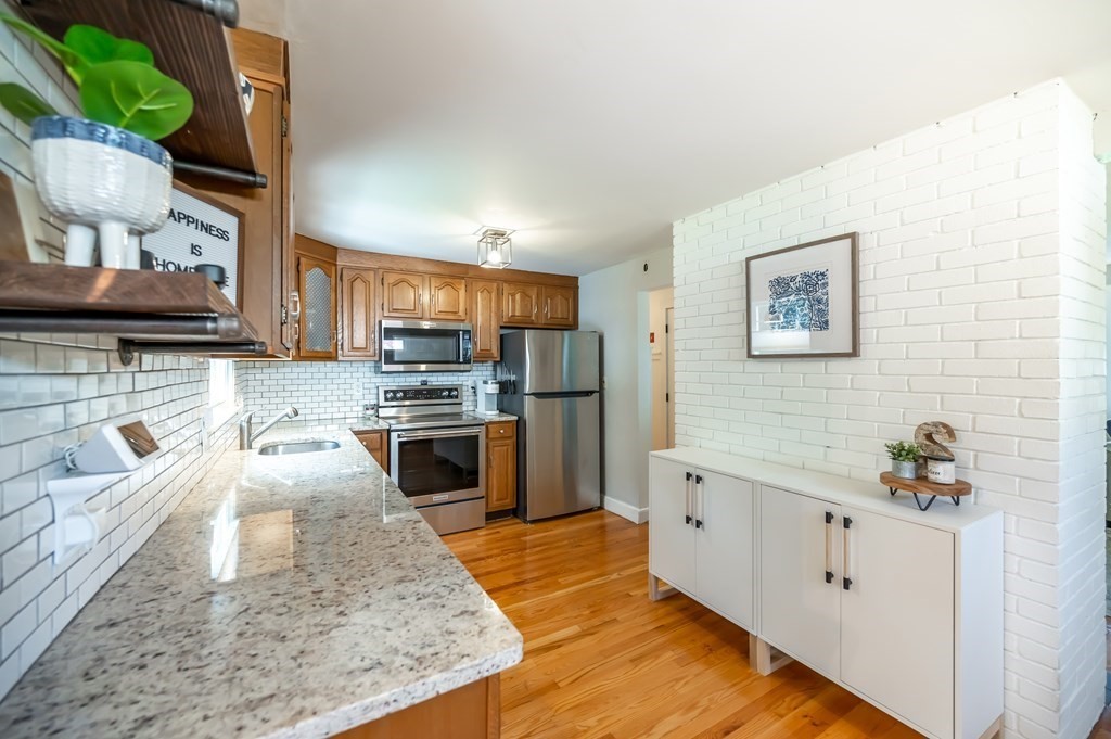 15 Anna Road Woburn, MA 01801 - Photo 12 of 28 a kitchen with stainless steel appliances kitchen island granite countertop a sink stove and cabinets
