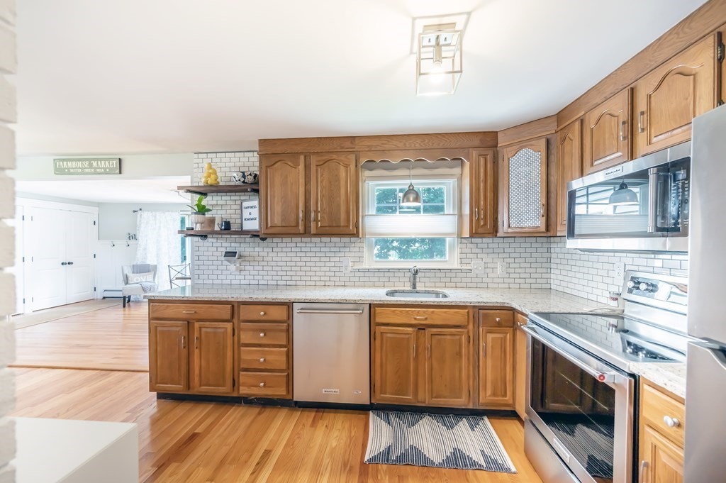 15 Anna Road Woburn, MA 01801 - Photo 13 of 28 a kitchen with a sink cabinets wooden floor and stainless steel appliances