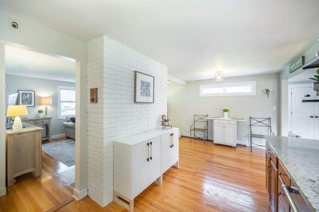15 Anna Road Woburn, MA 01801 - Photo 14 of 28 a large living room with stainless steel appliances kitchen island granite countertop a table chairs in it and a wooden floor