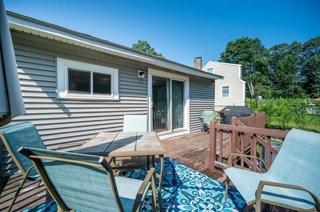 15 Anna Road Woburn, MA 01801 - Photo 25 of 28 a view of a patio with table and chairs with wooden floor and fence