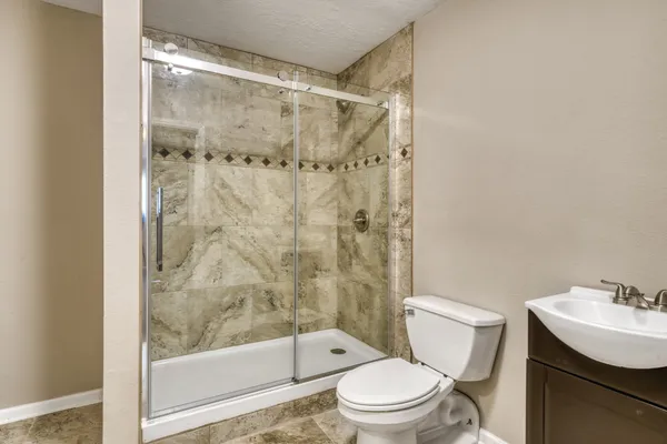 a bathroom with a shower a toilet and sink