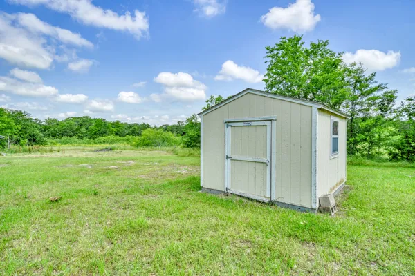 a view of a big yard with grass and a tree