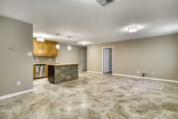 an empty room with kitchen appliances and windows