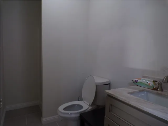 a bathroom with a granite countertop toilet and a sink