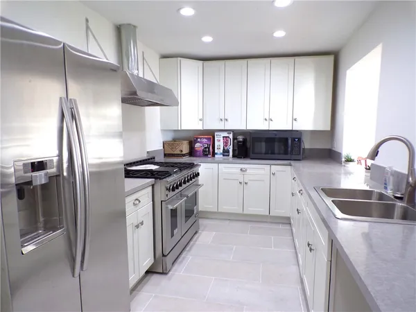 a kitchen with granite countertop a sink stainless steel appliances and cabinets