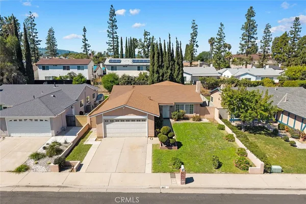 a aerial view of a house with a yard and potted plants