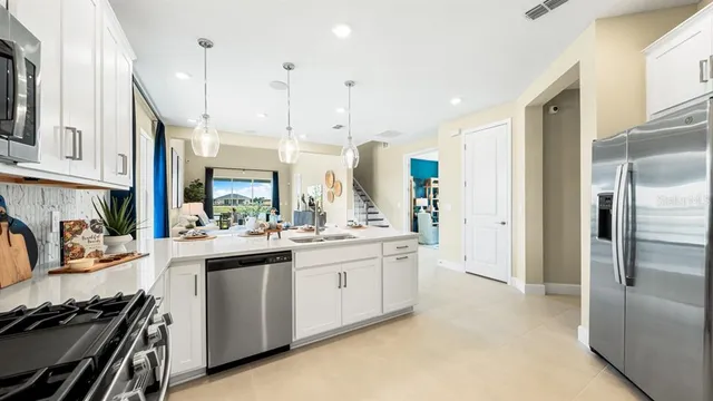 a dining room with stainless steel appliances kitchen island granite countertop a dining table and chairs