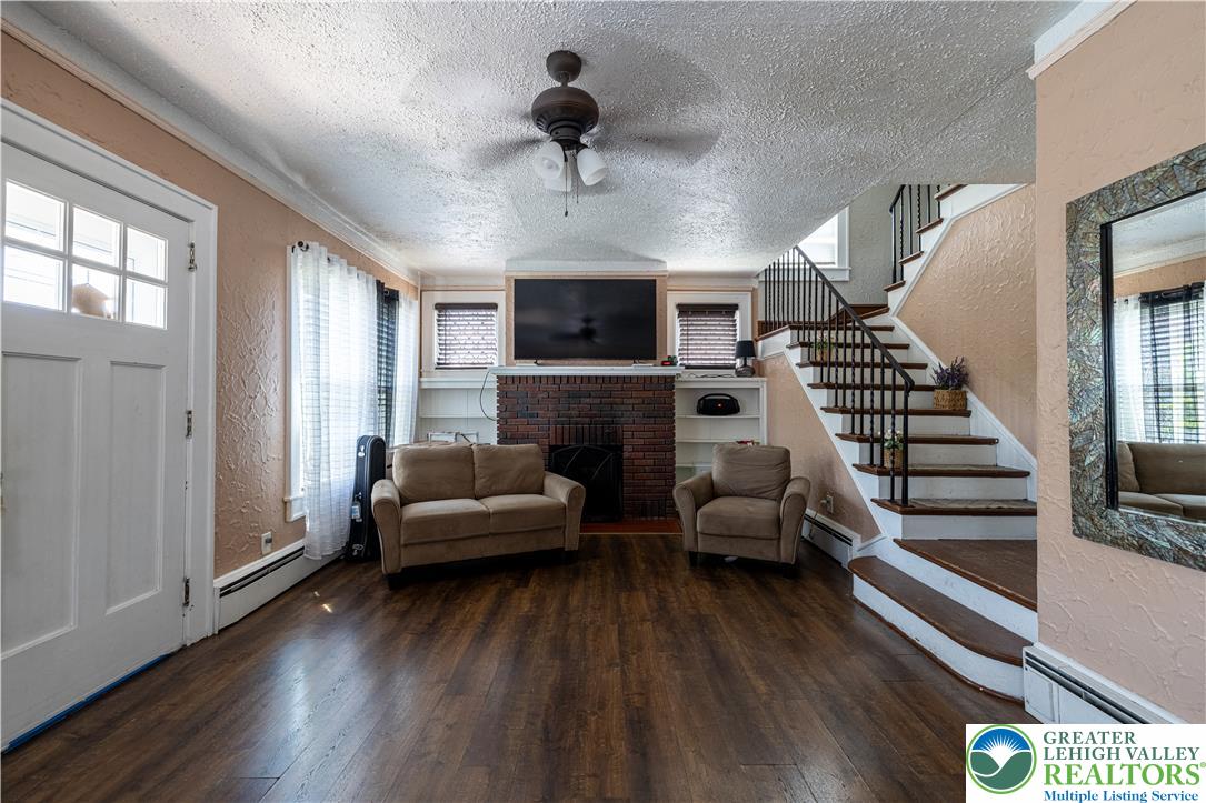 118 South 3rd Street Bangor, PA 18013 - Photo 3 of 33 This inviting living area features warm wood flooring and a classic brick fireplace.