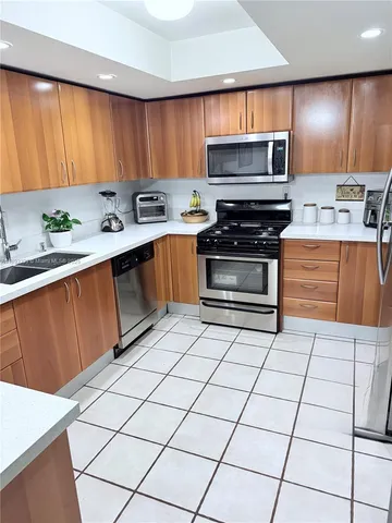 a kitchen with granite countertop a stove a sink and a microwave