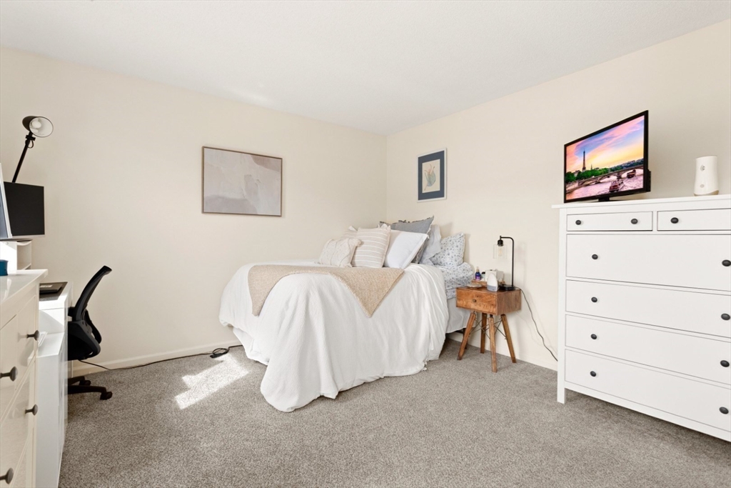 108 Abington Road, Unit 108 Danvers, MA 01923 - Photo 20 of 34 a bedroom with a bed and a flat tv screen on the dresser